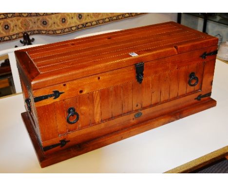 A stained pine wooden trunk, with cast iron corner mounts and rings, 32cm high x 74cm wide x 30cm deep
