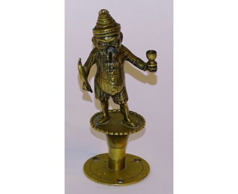 **A Victorian brass 'Mr Punch' bar lighter, with hole through cigar in Mr Punch's mouth, holding a writing quill in one hand 