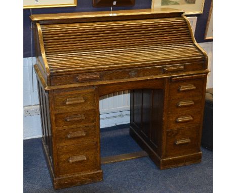 An oak roll top desk 'The Lebus Desk' by Harry Lebus circa 1930's, the tambour shutter enclosing fitted drawers and pigeon ho