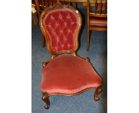 A Victorian walnut gossip chair, with button back and serpentine shaped seat, upholstered in red velour, 89cm high