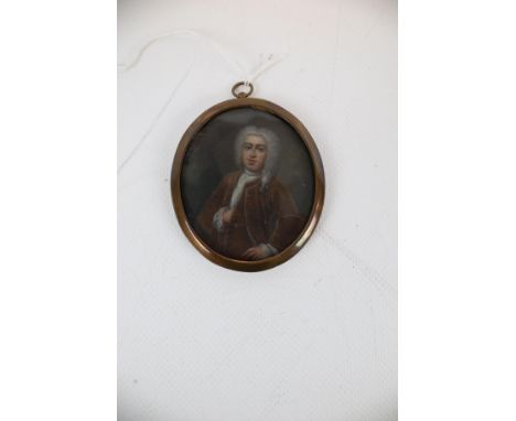 Miniature on Copper, an oval portrait of an 18th century Gentleman wearing a waistcoat and matching frock coat and wearing a 