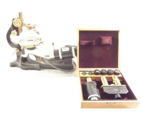 A binocular microscope by Ernest Leitz with boxed lenses, the microscope mounted with light source 