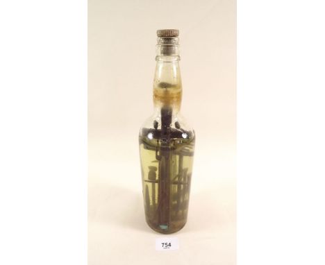 A 19th century Irish folk art 'God in a Bottle' containing carved wood selection of workman's tools, fish and birds