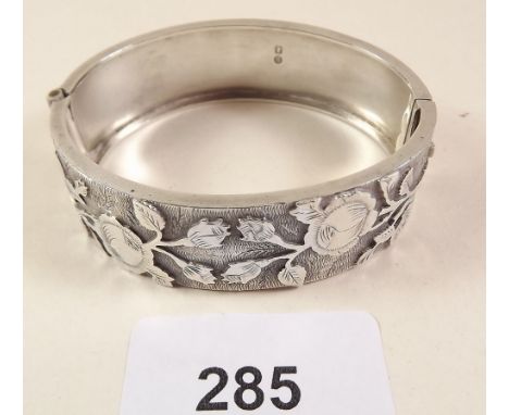 A hinged silver bangle decorated roses 