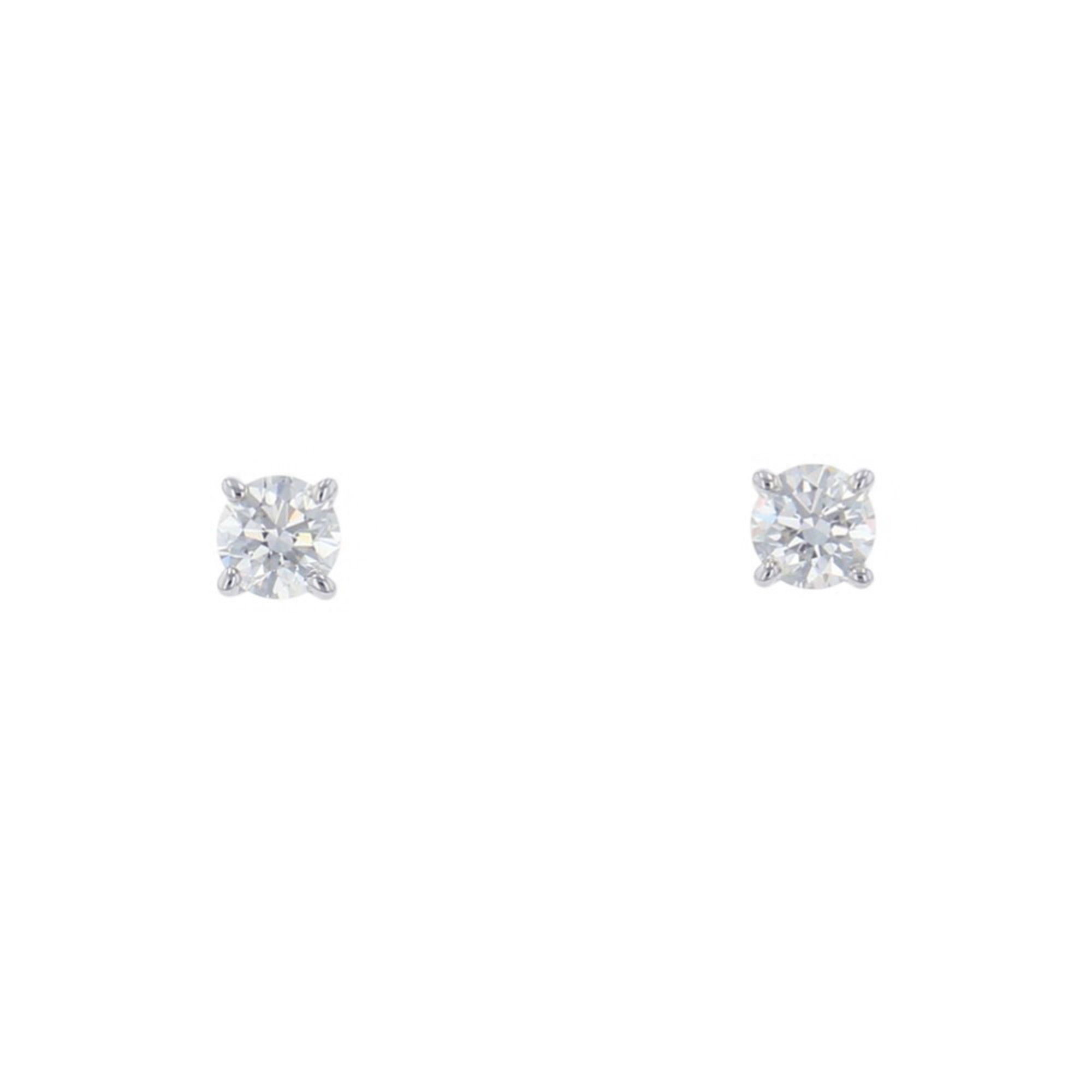 Tiffany & Co. solitaire diamond stud earrings with two diamonds totaling approximately 0.27 carats.