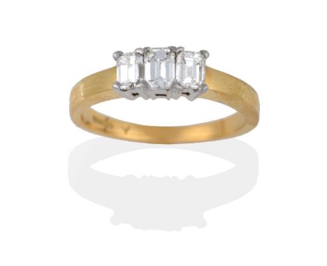 An 18 Carat Gold Diamond Three Stone Ring, the emerald-cut diamonds in white claws to a yellow plain polished shank, total es