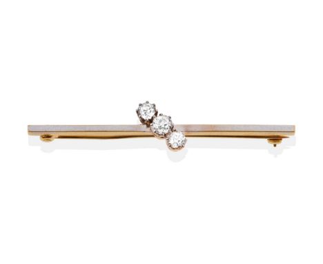 An Early 20th Century Diamond Three Stone Brooch, the old cut diamonds in white claw settings diagonally across the centre of