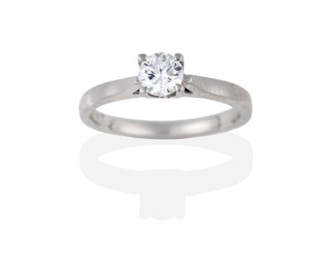 A Platinum Diamond Solitaire Ring, the round brilliant cut diamond in a four claw setting to tapered shoulders on a plain pol