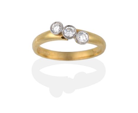 An 18 Carat Gold Diamond Three Stone Twist Ring, the round brilliant cut diamonds in white rubbed over settings, to a yellow 