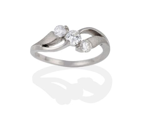 A Platinum Diamond Three Stone Ring, the round brilliant cut diamonds in double twist shoulders, part matt finished, to a pla