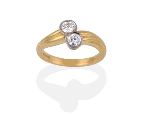 An 18 Carat Gold Diamond Two Stone Twist Ring, each round brilliant cut diamond in a white rubbed over setting, to yellow gro