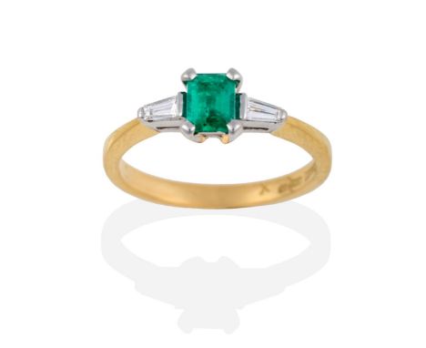 An 18 Carat Gold Emerald and Diamond Three Stone Ring, the emerald-cut emerald between two tapered baguette cut diamonds, in 