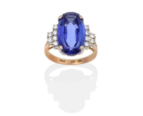 A Tanzanite and Diamond Ring, an oval cut tanzanite in a claw setting, to stepped diamond set shoulders, total estimated diam