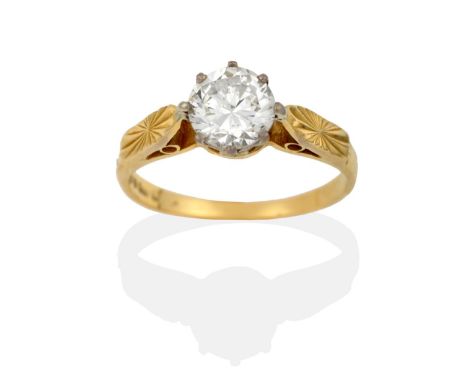 An 18 Carat Gold Diamond Solitaire Ring, a round brilliant cut diamond in a white claw setting, to carved yellow shoulders on