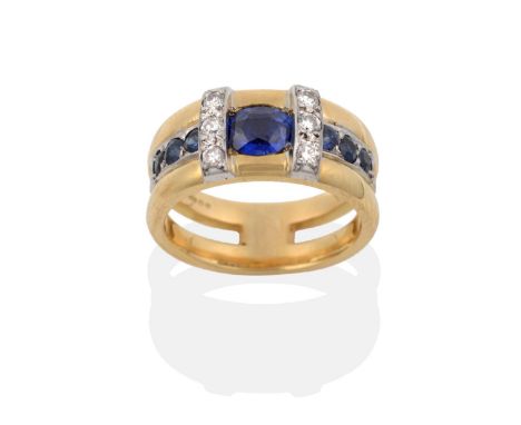 An 18 Carat Gold Contemporary Sapphire and Diamond Ring, an oval cut sapphire, within a trio of sapphires to each side, with 