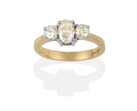 An 18 Carat Gold Diamond Three Stone Ring, an oval cut diamond between two round brilliant cut diamonds in white claw setting