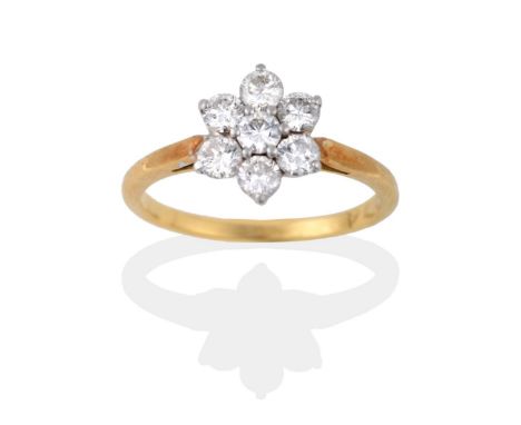 An 18 Carat Gold Diamond Cluster Ring, the round brilliant cut diamonds in white claw settings, to a yellow pointed shoulder 