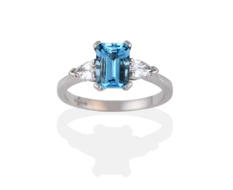 An 18 Carat White Gold Aquamarine and Diamond Three Stone Ring, the emerald-cut aquamarine between two pear cut diamonds, in 