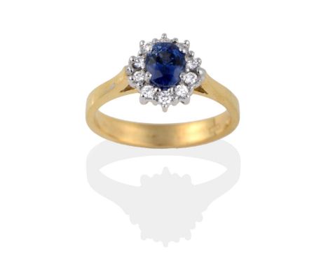 An 18 Carat Gold Sapphire and Diamond Cluster Ring, the oval mixed cut sapphire within a border of round brilliant cut diamon