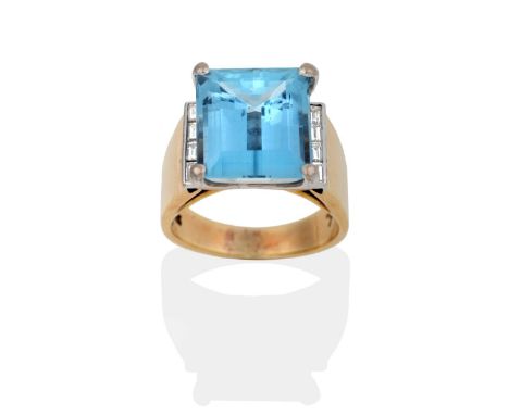 An Aquamarine and Diamond Ring, an octagonal cut aquamarine in a claw setting, to channel set baguette cut diamond shoulders,