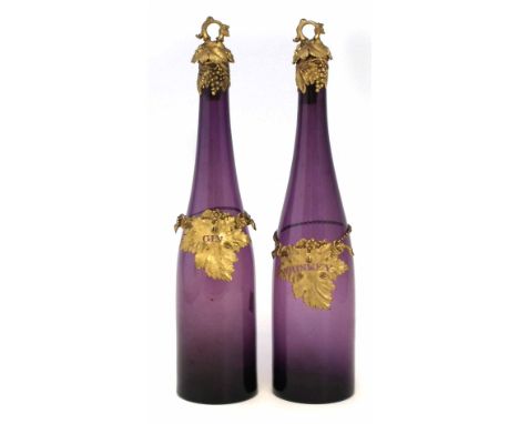 Pair of purple glass bottle decanters, with gilt tops and stoppers, with labels 'Whiskey' and 'Gin', 19th century, (2) 34cm h