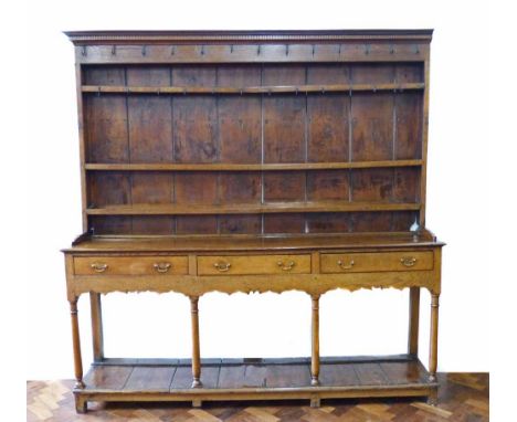 18th century oak dresser, upper section with three shelf rack supporting original steel cup hooks, base with three frieze dra