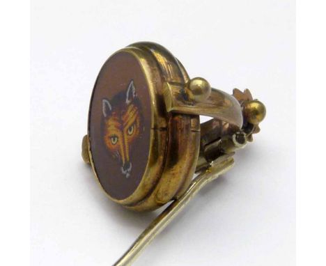 Gilt metal stick pin set with a rotating enamelled tablet of a fox mask and a horse "Archer", in a spur shaped mount.