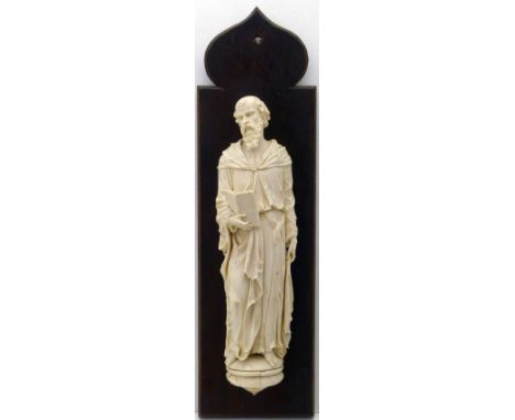 Dieppe ivory figure of a saint, possibly St John, holding a book, late 19th century, height 37cm, on an oak mount. Condition 