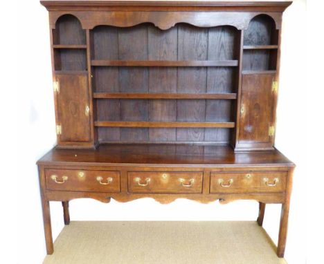 George III oak dresser, shaped frieze, three shelf plate rack flanked by two cupboards, base with three drawers, original bra