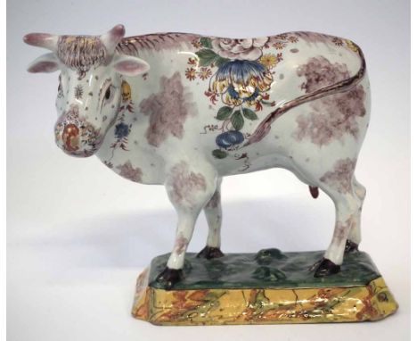 Van Duijn Delft cow, painted with floral sprays modelled standing on a grassy base, painted mark to base, mid 18th century, 1
