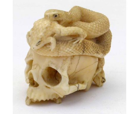 Japanese carved ivory netsuke of a human skull entwined by a snake and two toads, Meiji period, height 4.5cm. Condition repor