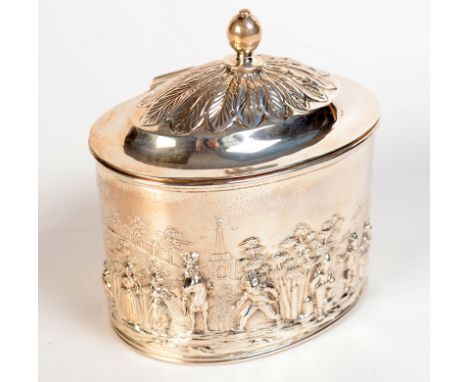 An oval Victorian silver tea caddy in Dutch style, cast with peasants in a landscape, the lid domed and crowned with leaves, 