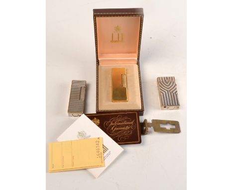 A Swiss Dunhill gas lighter, original box and instructions, a rare fluted Dunhill lighter, one other Dunhill lighter and a th