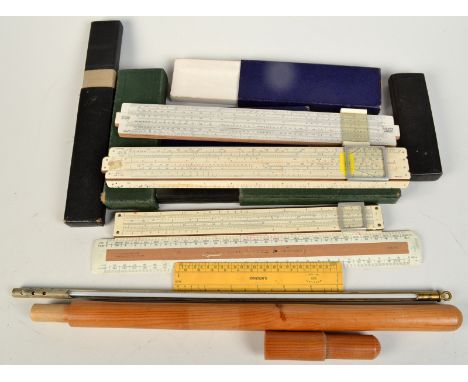 Three slide rules, two other rulers and a brass thermometer in a wooden case. 
