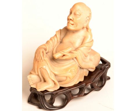 A good Chinese carved soapstone seated Lohan holding a scroll. Height including carved hardwood stand 7cm.  Condition Report: