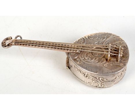 A miniature silver mandolin with scrolling ornamentation and with four individual strings. The back panel, decorated with a g