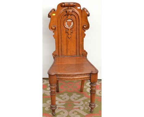 A light oak hall chair with cartouche back.
