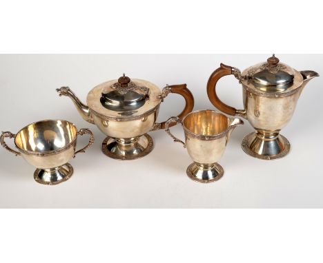 An Irish silver Mappin & Webb four piece tea service with bands of Celtic decoration, the wooden handles and the spouts model