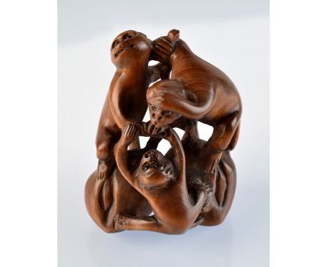 A wooden netsuke carved as three apes standing on a fruiting branch.  Signed.