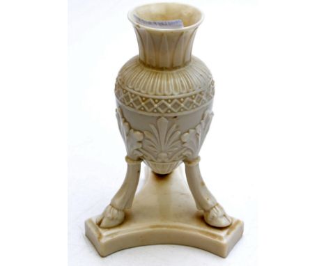 A Belleek tripod vase, black mark, 17cm. Condition Report: A chip to the rim and a couple of minute firing flaws to the body,