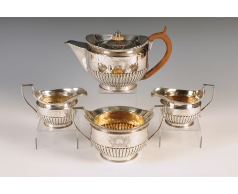 A George III silver round four piece tea service, each half fluted with gadrooned rims and engraved armorials, by Richard Coo