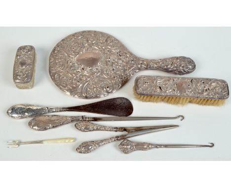 A silver cased mirror, silver backed brush, silver handled button hooks etc.
