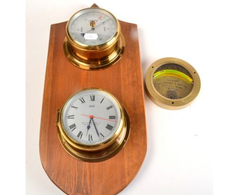 A Sestrel brass bulkhead quartz timepiece and aneroid barometer on a pine mount, together with a circular brass spirit level 