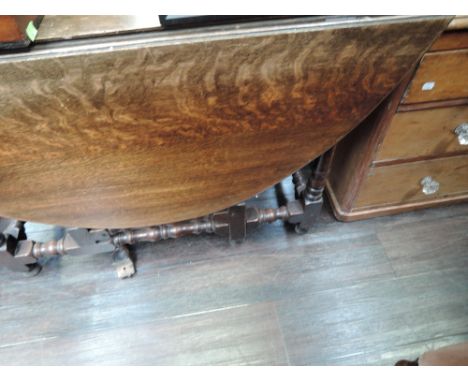 A 19th century oak dining table in the 17th century style having oval top and frieze drawer on bobbin gate legs