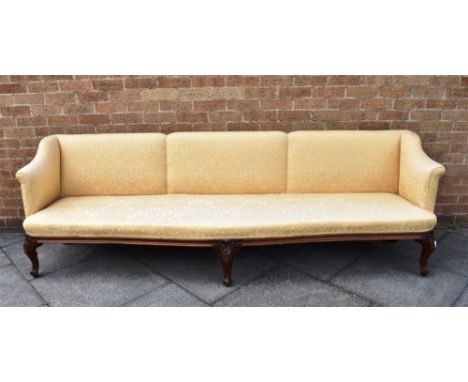 AN UPHOLSTERED LONG SOFA  with scroll arms, on three carved cabriole front supports, 250cm long, 70cm deep 106cm high
