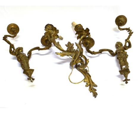 A PAIR OF GILT METAL TWO LIGHT FIGURAL WALL LIGHTS  each with a cherub term supporting rococo scroll arms, 49cm high excludin