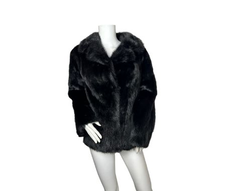 A vintage black stranded mink jacket with black faille lining. The jacket has set in pockets, self lined collar and two furri