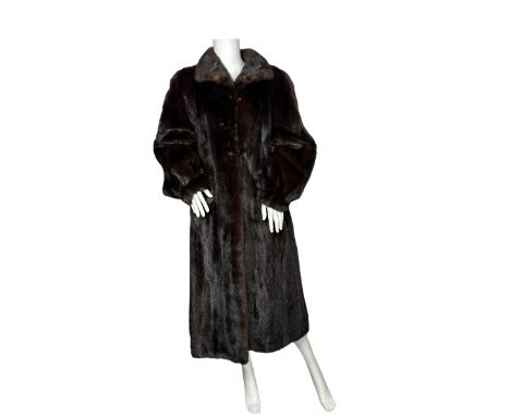 A vintage 1980s ranch mink coat with dark chocolate lining. The coat has balloon sleeves that taper at the wrist and small se
