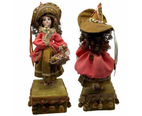 A vintage, unmarked automata musical porcelain doll with fully functional mechanical movements which bring her arm up to her 