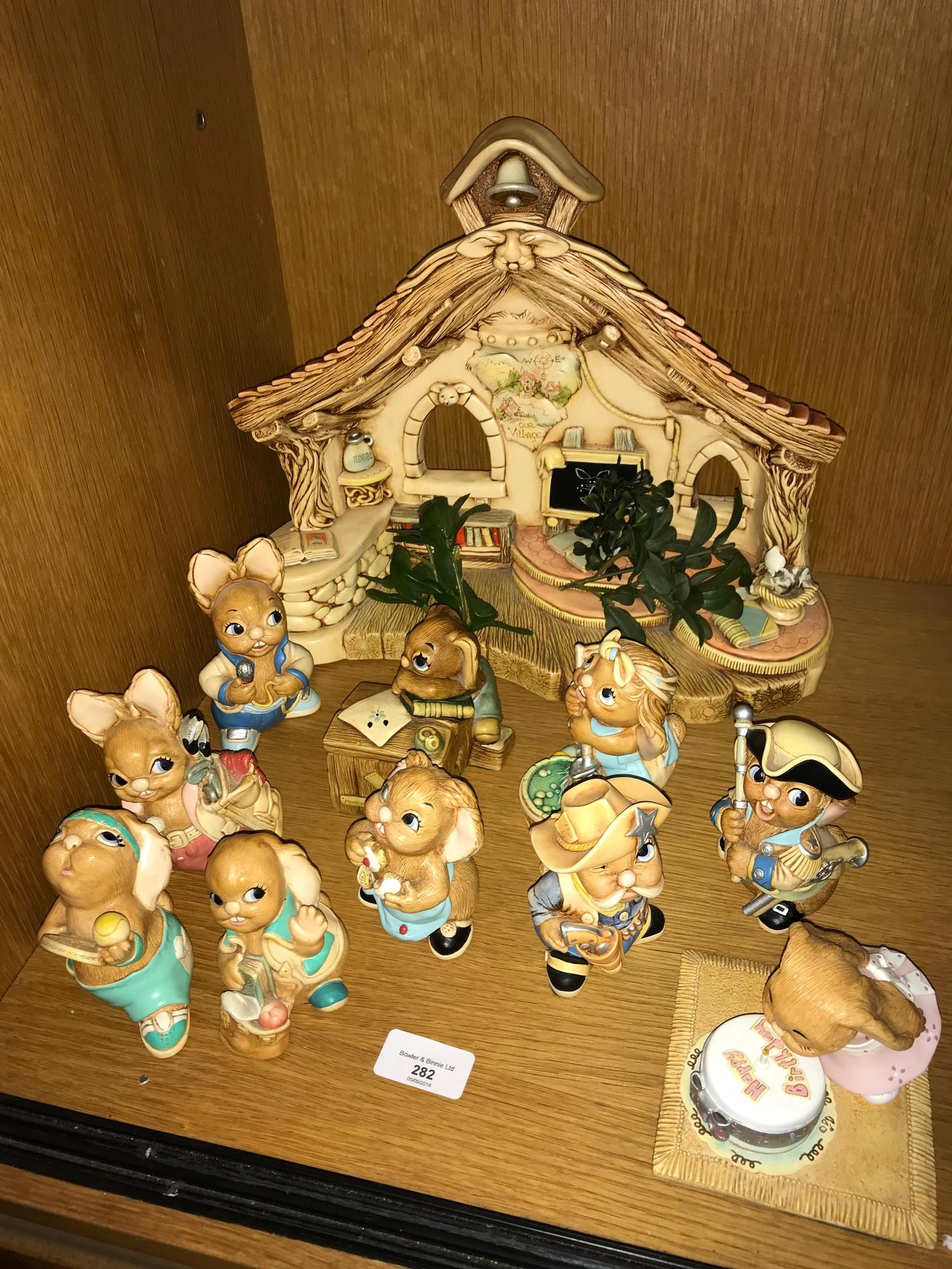A Collection of pendelfin rabbit figures which includes display stand